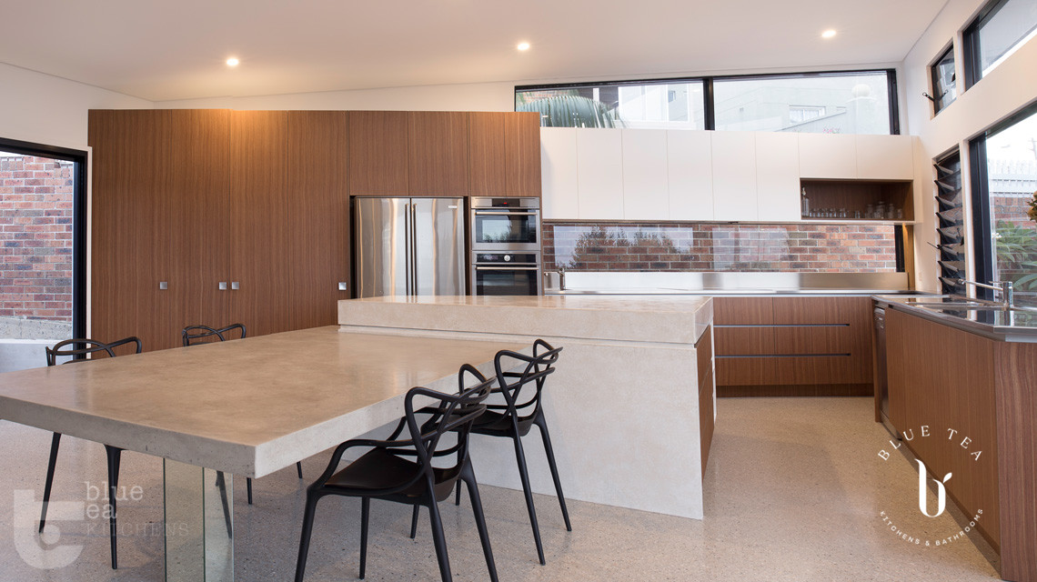 modern kitchen using concrete floors, timber veneer and polyurethane cabinets