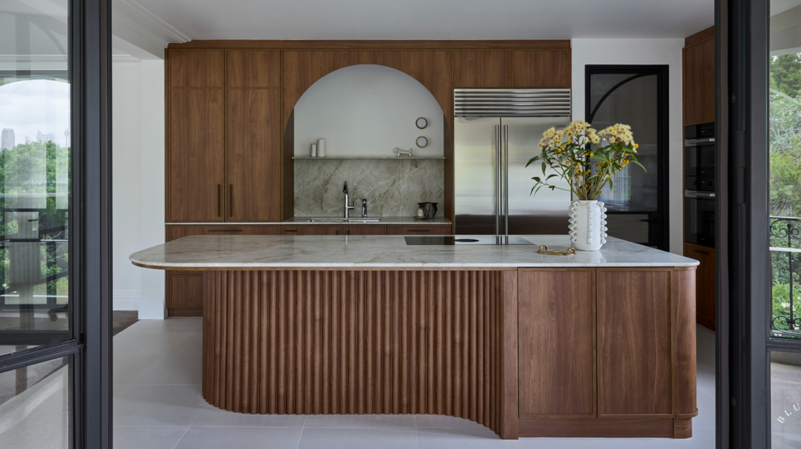 Timber shaker kitchen with a feature ribbed and curved island with natural stone