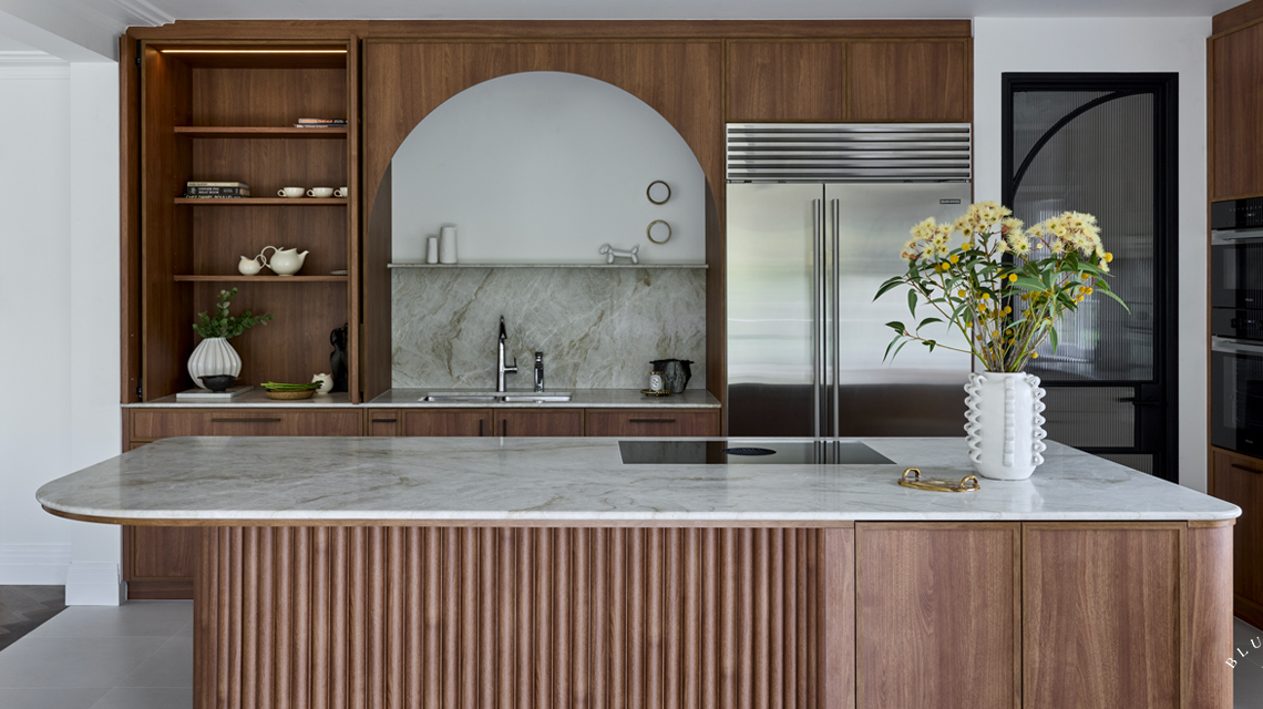 A curved island is offset with a curved joinery back wall and timber ribbing.